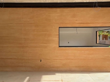 Revestimento Natural de Terra: A conexão com a natureza presente, além da beleza natural e dos benefícios ambientais e sensoriais da Biofilia. Outra vantagem que destacamos, é que o Revestimento natural de terra pode ser aplicado sobre uma alvenaria convencional.