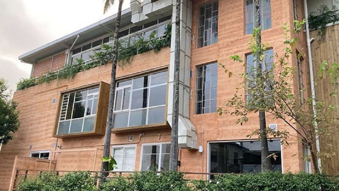 O revestimento de terra foi concebido como o elemento central do projeto, representando os valores de conexão com a natureza e hospitalidade refletidos no nome Mãe Terra. O uso de Revestimento TAIPAL (revestimento natural de terra) contribui para o desempenho térmico e acústico e promove a saúde dos ambientes ao funcionar como um filtro de ar, realizando trocas higroscópicas benéficas.